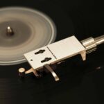 Tonarm mit Headshell über einer laufenden Schallplatte