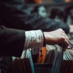 Hand blättert durch Schallplatten in einem Plattenladen