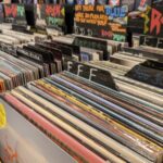 Bunte Schallplatten-Cover in den Fächern eines Plattenladens